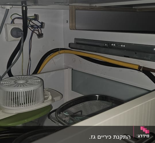 צינור גז צהוב ומחברים בארון מטבח